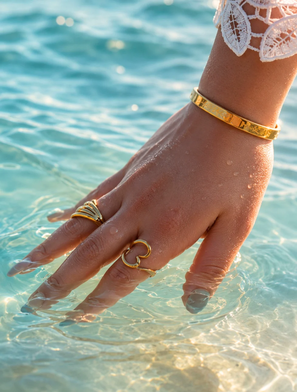 Kanyo manicure and gold jewelry photographed in blue water